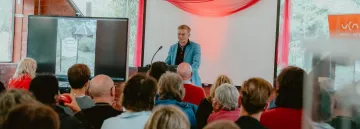 Person speaking to crowd of people