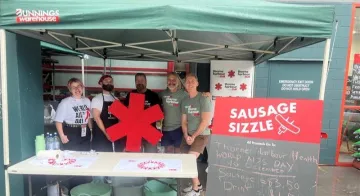 People standing behind a barbecue